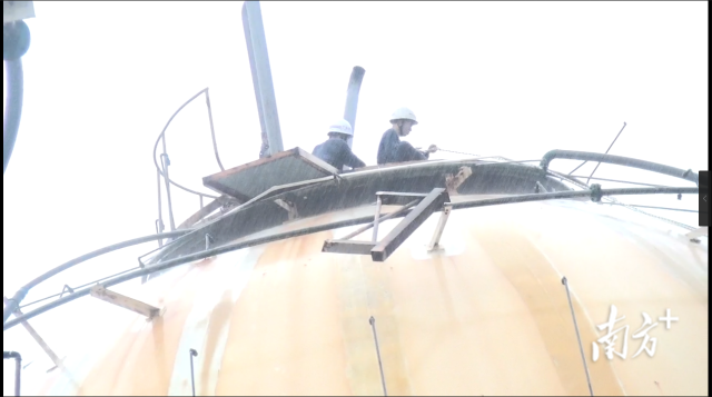 张志添正在液化石油气罐顶上堵漏。