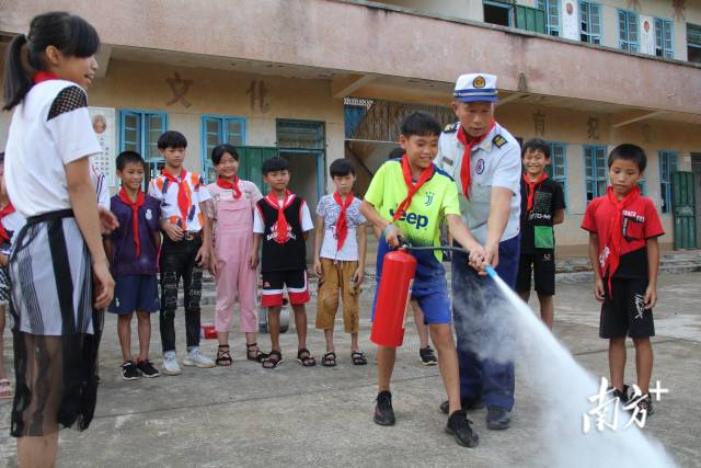 张志添在教学生如何使用灭火器。
