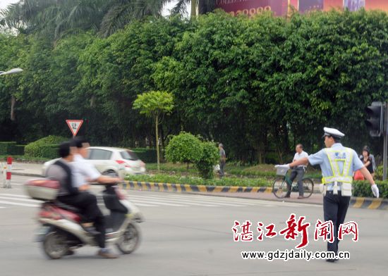 一中年男子骑电动车窜进路口快速闯红灯穿行,被执勤交警及时制止。