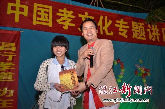 宋乃裕主编在互动后为学生送上《中国孝文化读本》(潘海其 摄)