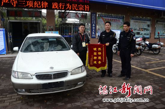 交警赤坎大队教导员赵文科、识假能手陈贤松接过印有“热情服务 破案神速”的锦旗。