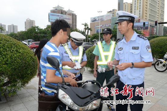 汤乐泉副大队长现场对电动车冲红灯驾驶员进行教育。