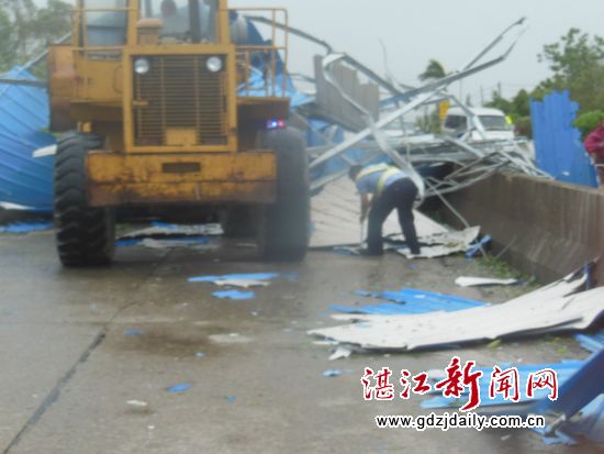 请来铲车清除被吹倒在国道上的障碍物