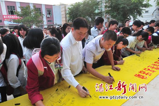 11月24日下午5时30分,在湛江市实验中学舞台前,数百名学生争先恐后地在招募志愿者签名的黄色长绸中签上了自己的名字,场面特别踊跃……