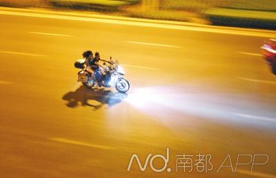 摩托车轰鸣而过。