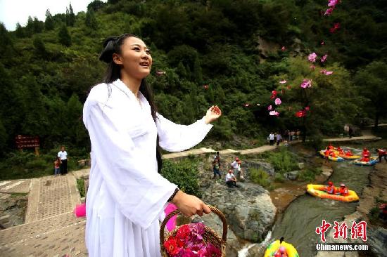 8月20日，中国传统节日七夕节，网友在河南三门峡豫西大峡谷装扮花千骨，超凡脱俗、精美淡雅、轻盈飘逸,仙气十足，粉丝直呼太逼真。她矗立鹊桥之上，天女撒花“银河”洒落花瓣雨祝福同船共渡漂流情侣天长地久。吸引上百漂流船停泊驻足观美人。王中举 摄