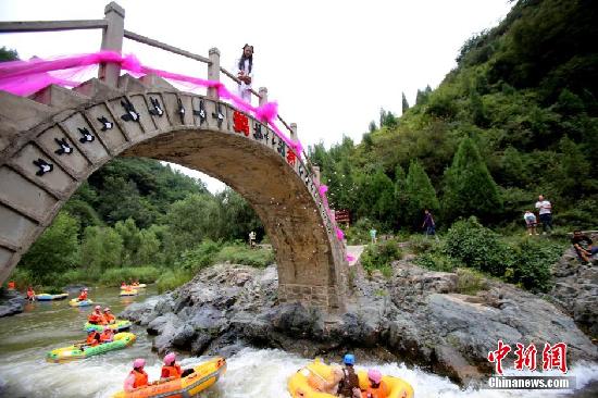 8月20日，中国传统节日七夕节，网友在河南三门峡豫西大峡谷装扮花千骨，超凡脱俗、精美淡雅、轻盈飘逸,仙气十足，粉丝直呼太逼真。她矗立鹊桥之上，天女撒花“银河”洒落花瓣雨祝福同船共渡漂流情侣天长地久。吸引上百漂流船停泊驻足观美人。王中举 摄