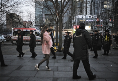 昨日下午，一名女子从正在巡逻的民警和保安身旁走过。